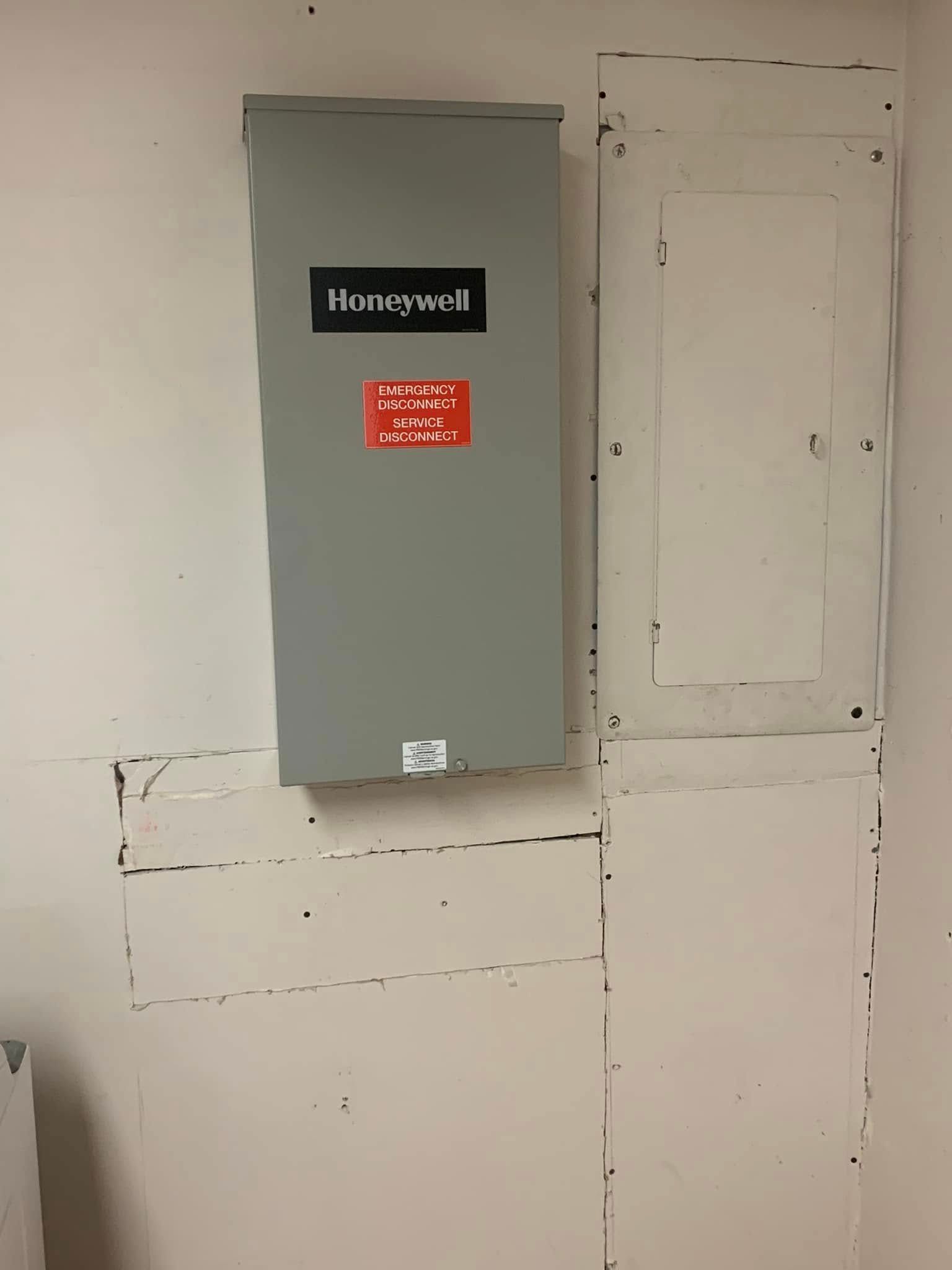 A honeywell box is hanging on a white wall