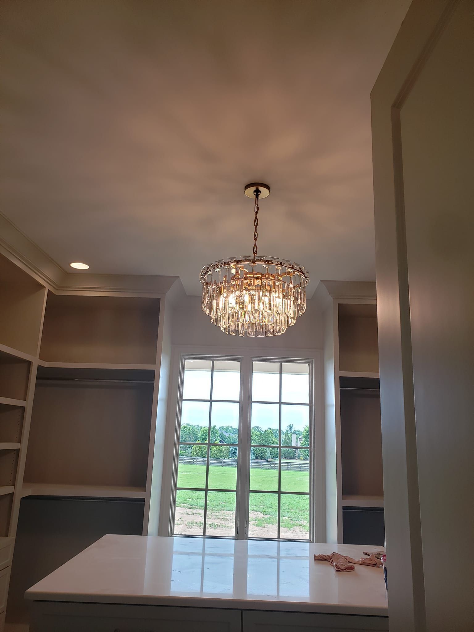 A walk in closet with a chandelier hanging from the ceiling