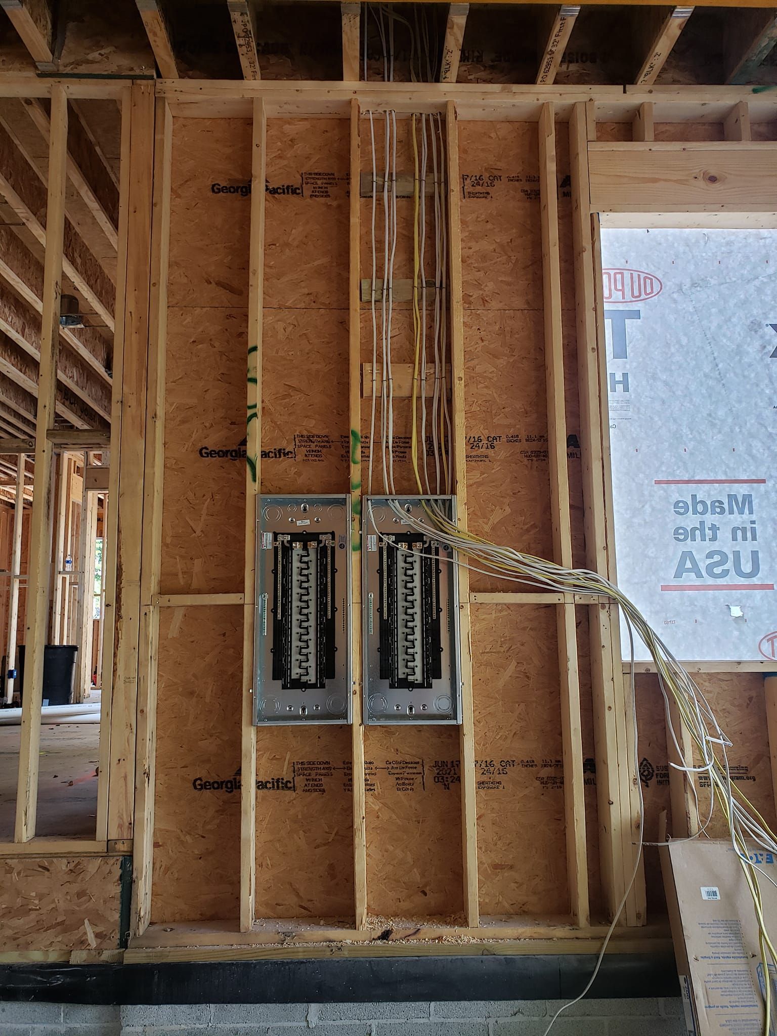 A house is being built with a lot of wires coming out of it