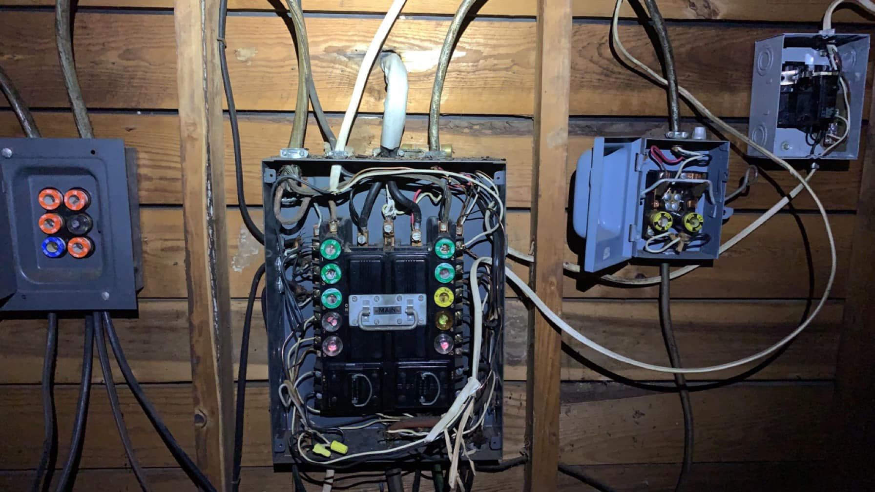A bunch of wires are hanging from the ceiling of a house.