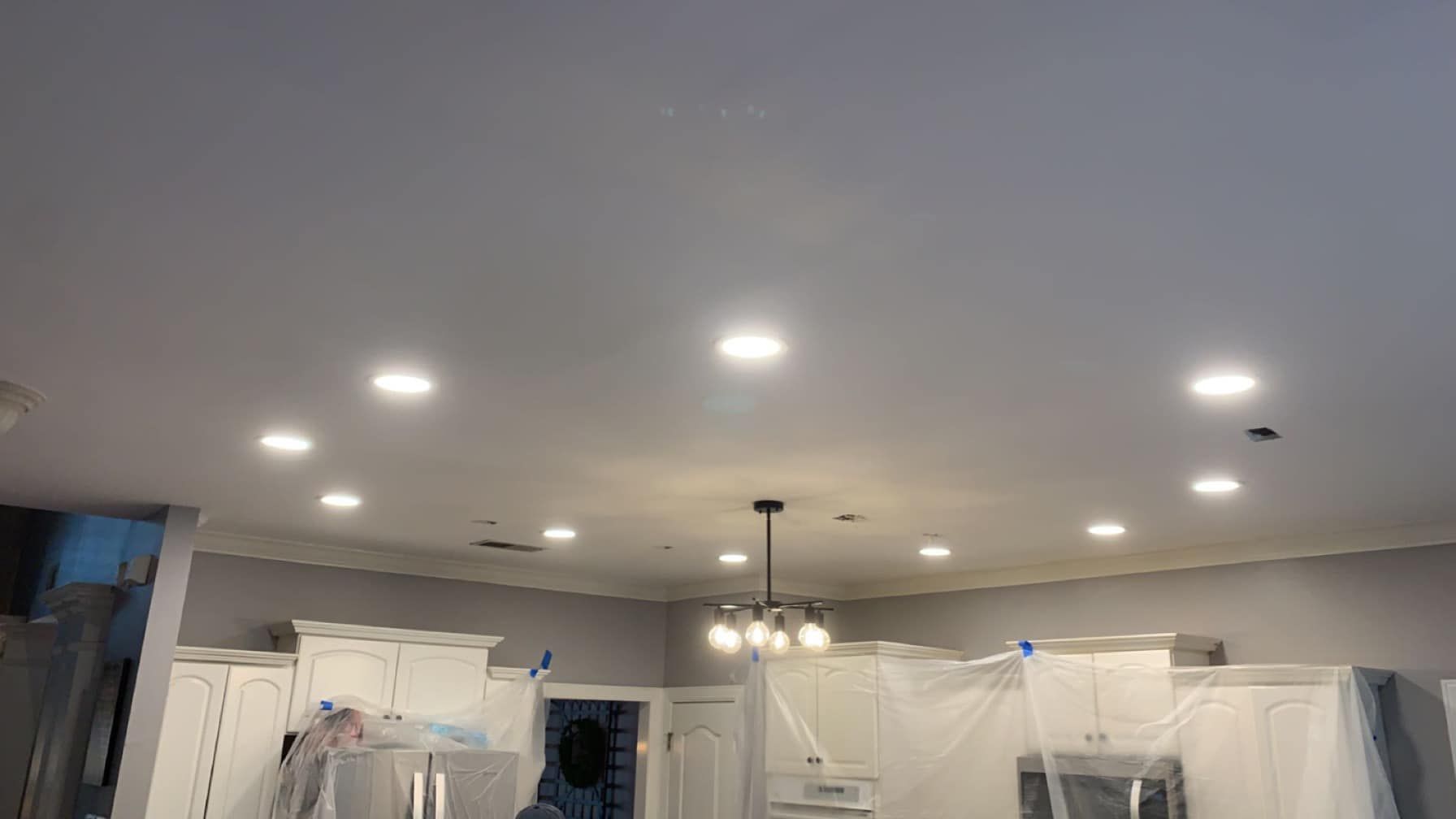 A kitchen with white cabinets and a white ceiling.