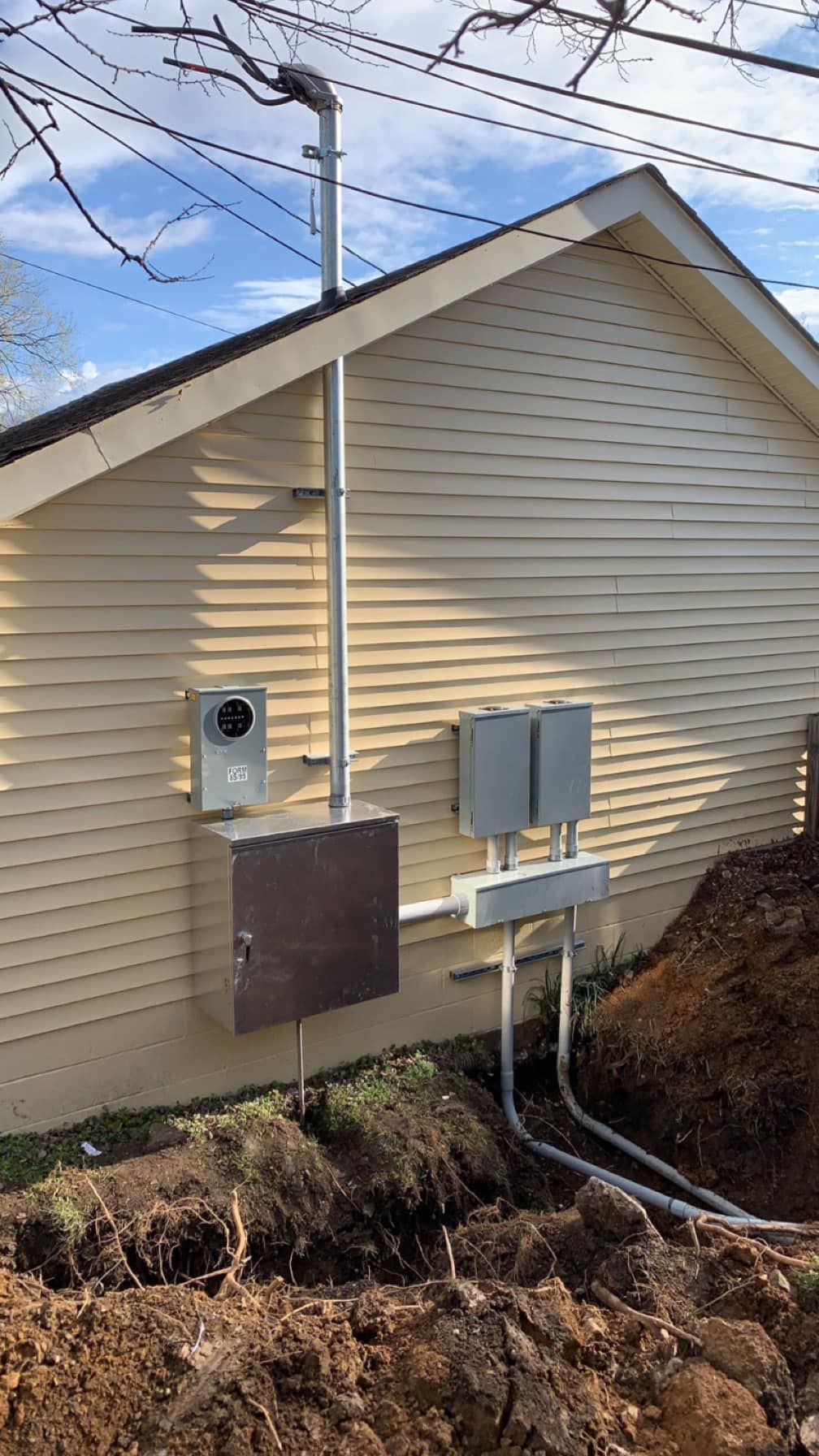A house with a lot of electrical equipment on the side of it.