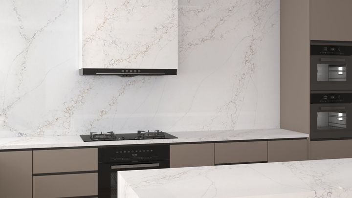 Modern kitchen with white marble-like backsplash and countertop, black appliances, and neutral-toned cabinetry.