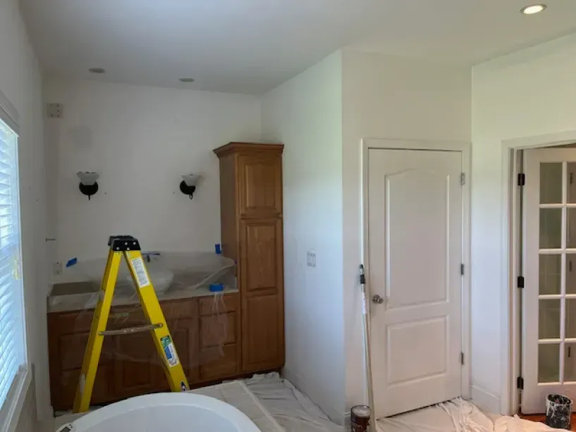 A bathroom with a bathtub and a ladder in it.