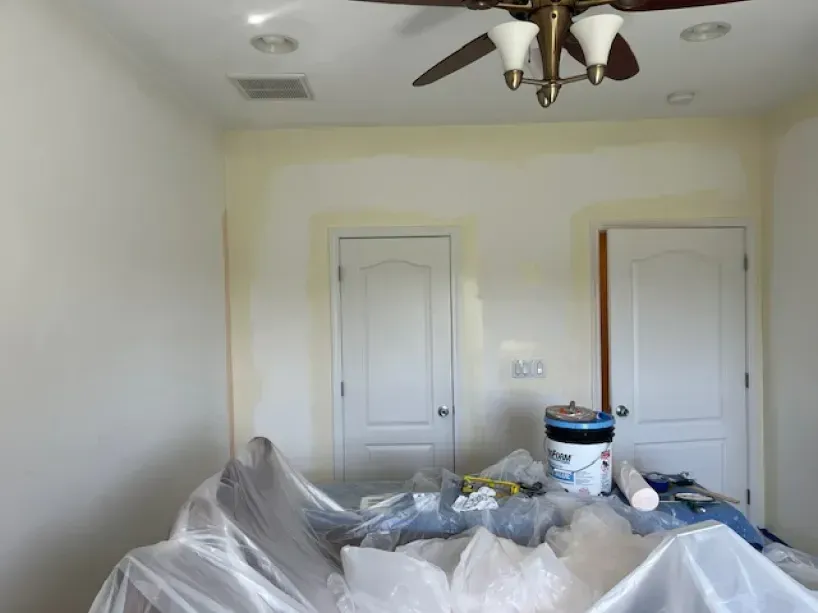 A room with white walls and a ceiling fan