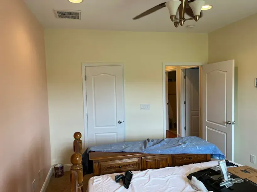 A bedroom with a bed and a ceiling fan.