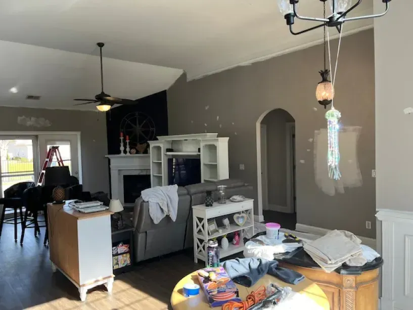 A living room with a couch and a fireplace and a chandelier hanging from the ceiling.