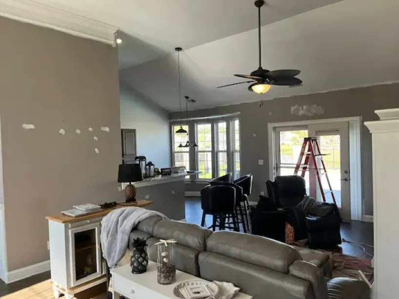 A living room with a couch and a ceiling fan.