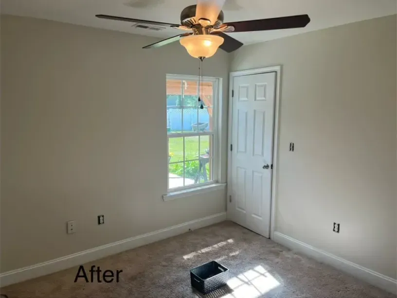 A room with a ceiling fan and a window with the words after on the bottom