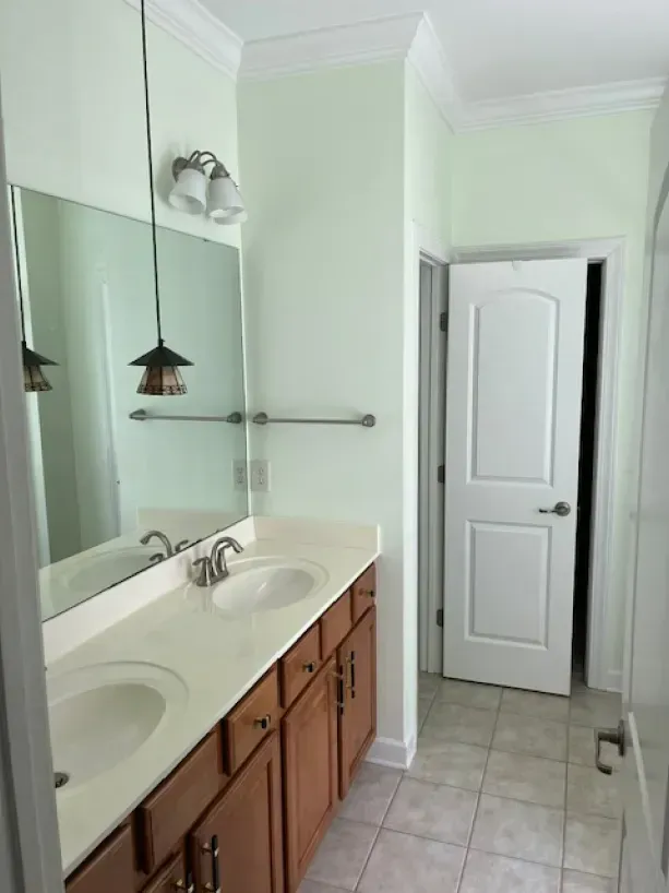 A bathroom with two sinks and a large mirror