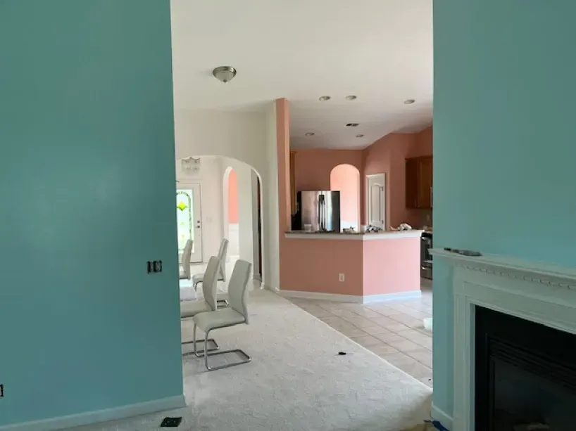 A living room with blue and pink walls and a fireplace