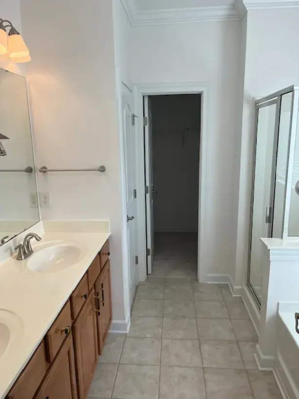 A bathroom with a sink , mirror , and walk in shower.