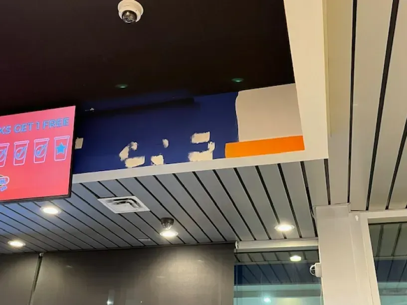 A ceiling with a sign that says ' no cashiers ' on it