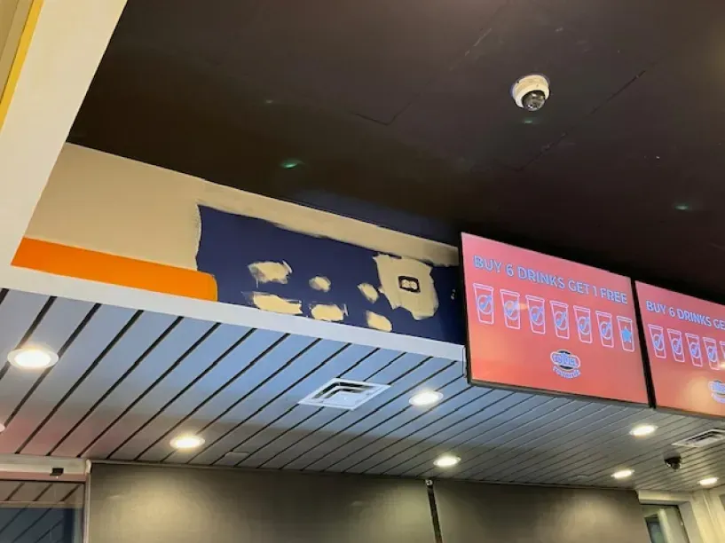 The ceiling of a restaurant with a sign that says ' chicken nuggets ' on it