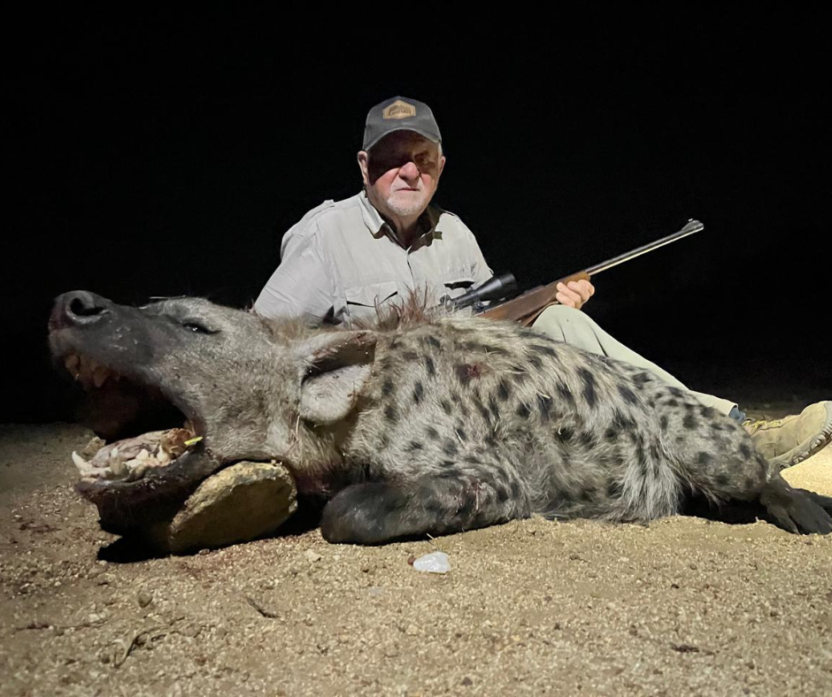 un cazador nocturno con hiena