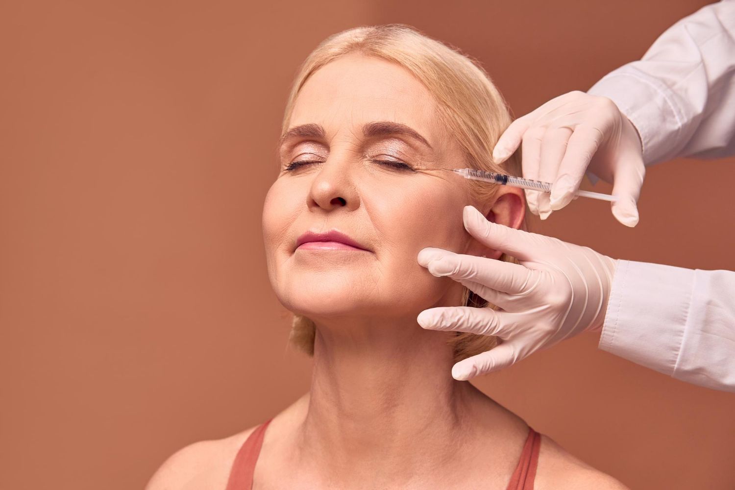 A woman is getting a botox injection in her face.