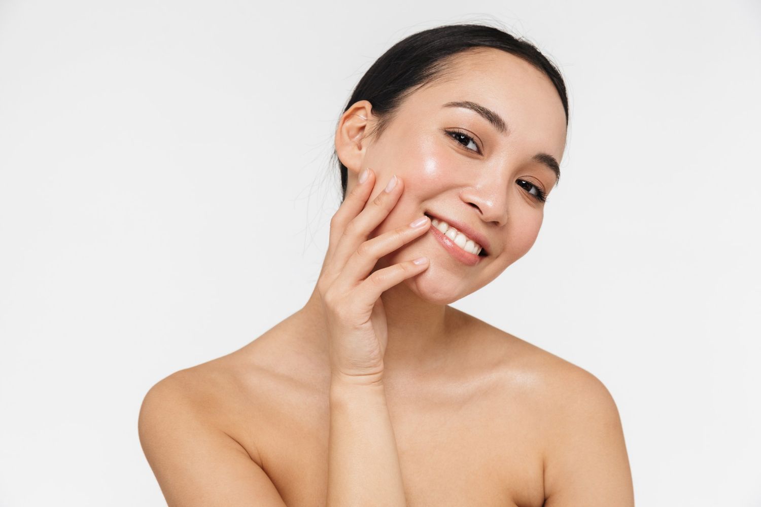 Portrait of a smiling woman touching her face over white background