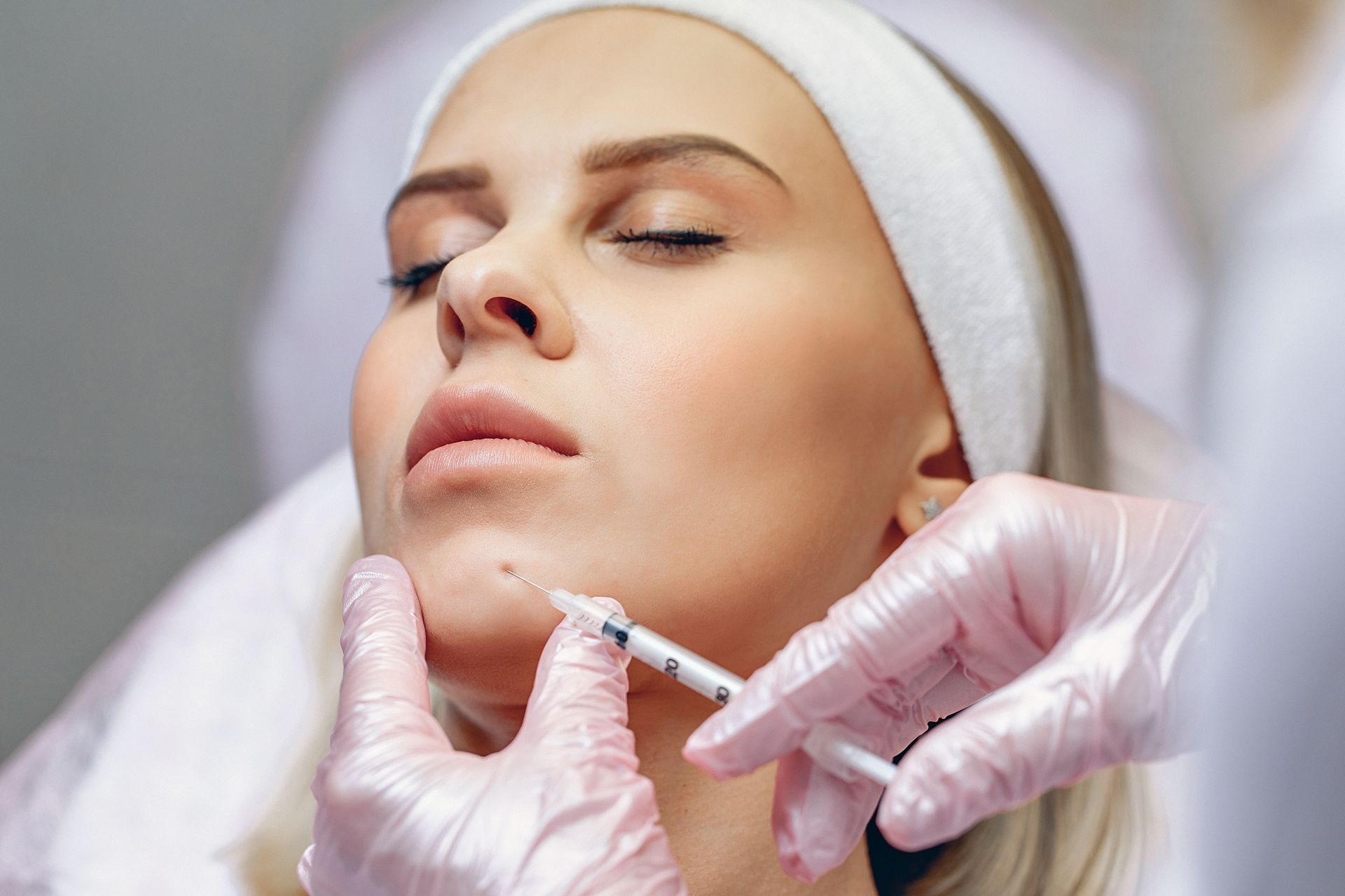 A woman is getting a botox injection in her face.