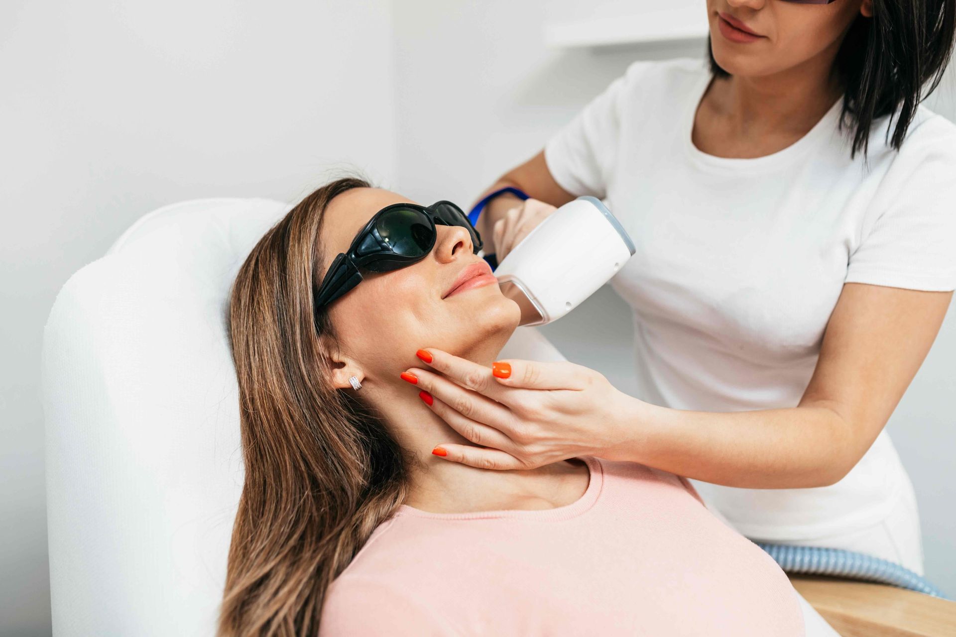 a woman is getting a laser hair removal treatment on her face .