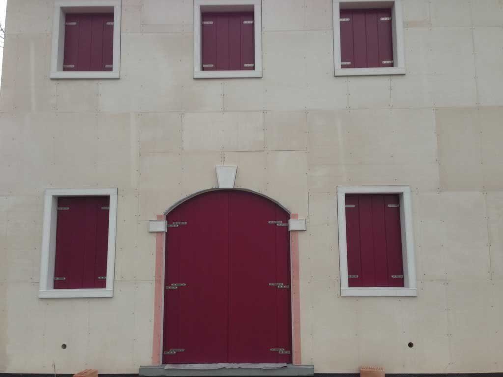 Portone con scuri e finestre con persiane