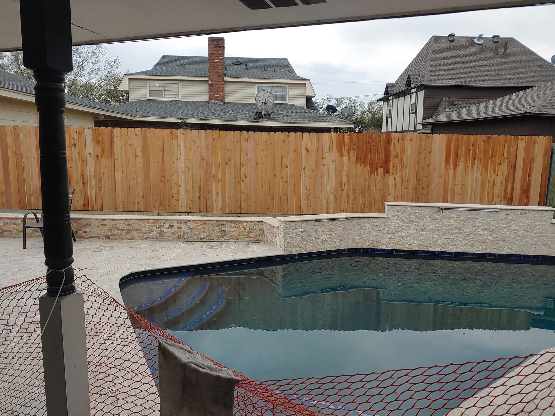 A swimming pool with a wooden fence surrounding it