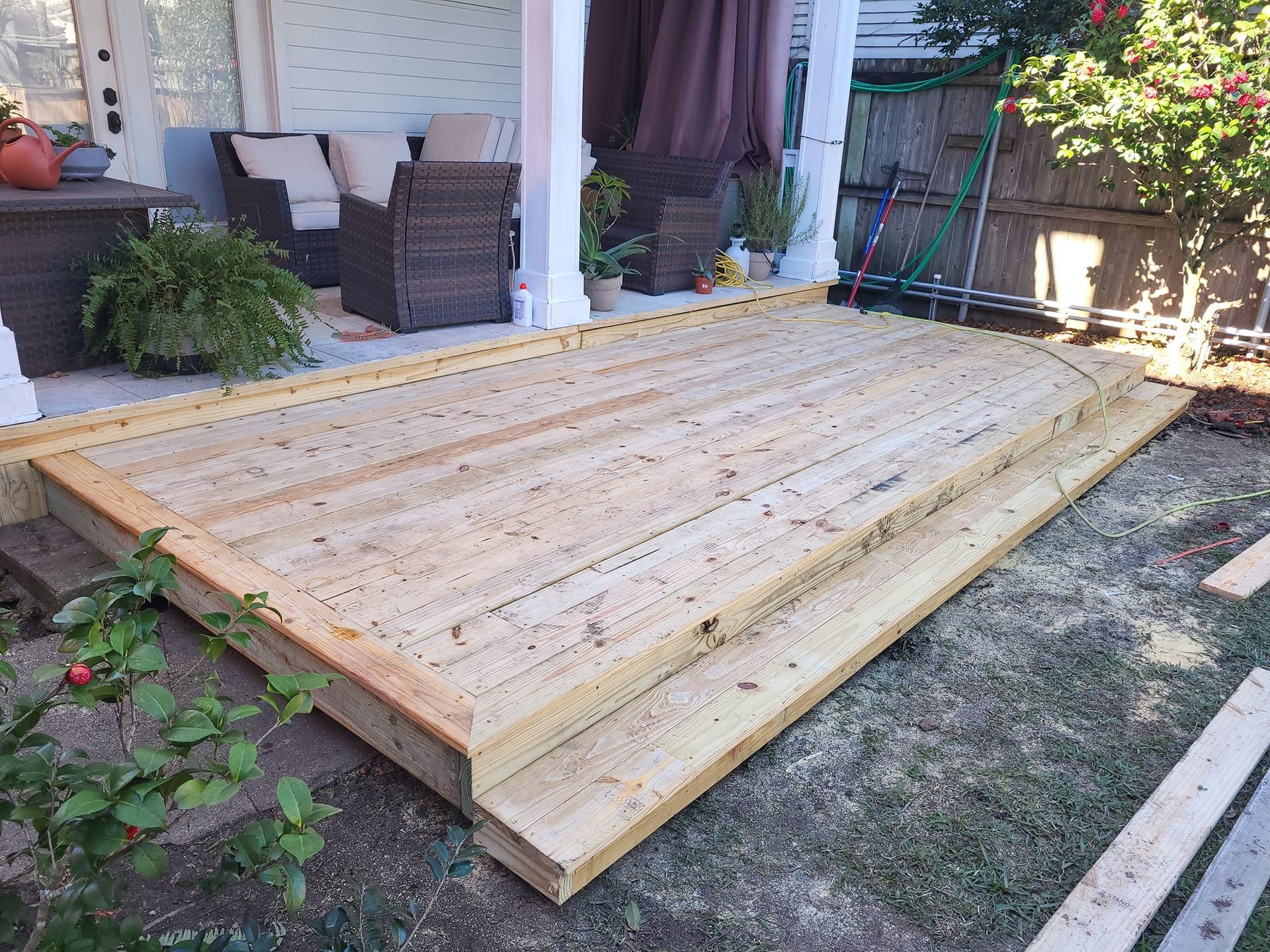 A wooden deck is being built in the backyard of a house.