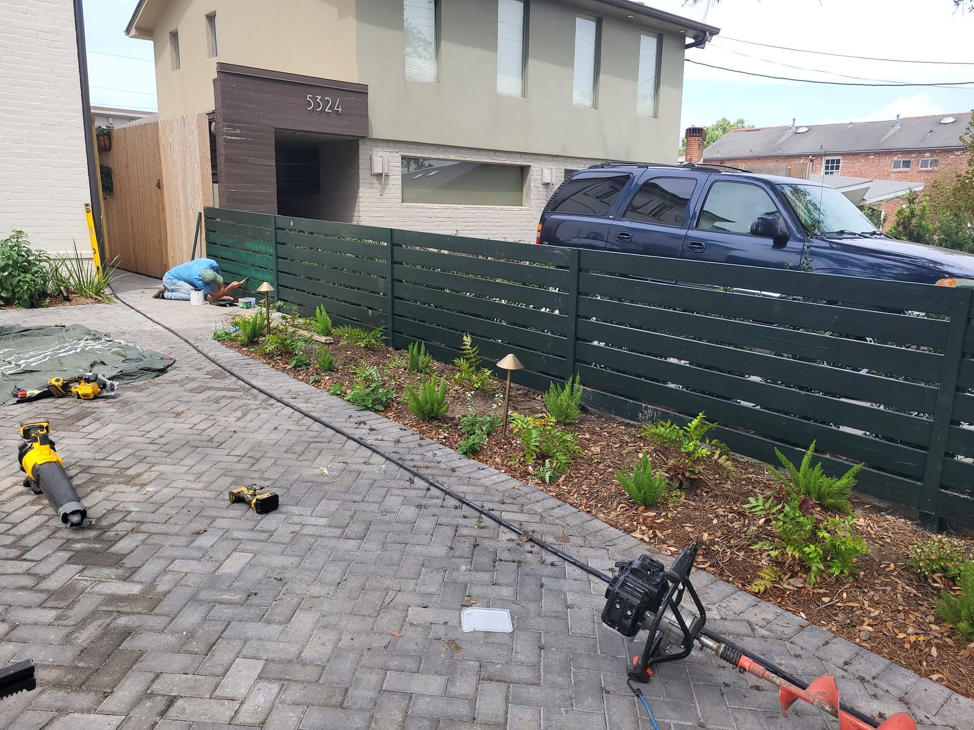 A black fence is being built in front of a house.