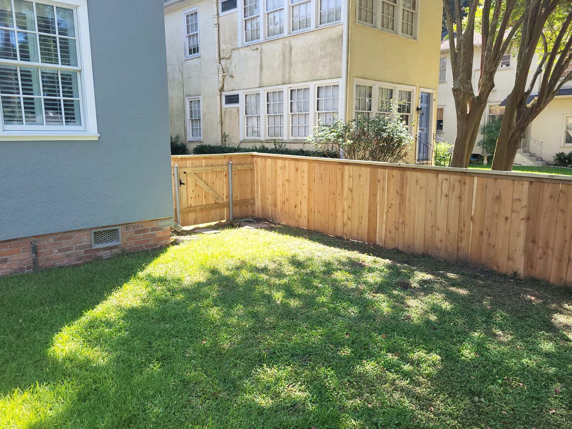 There is a wooden fence in the backyard of a house.