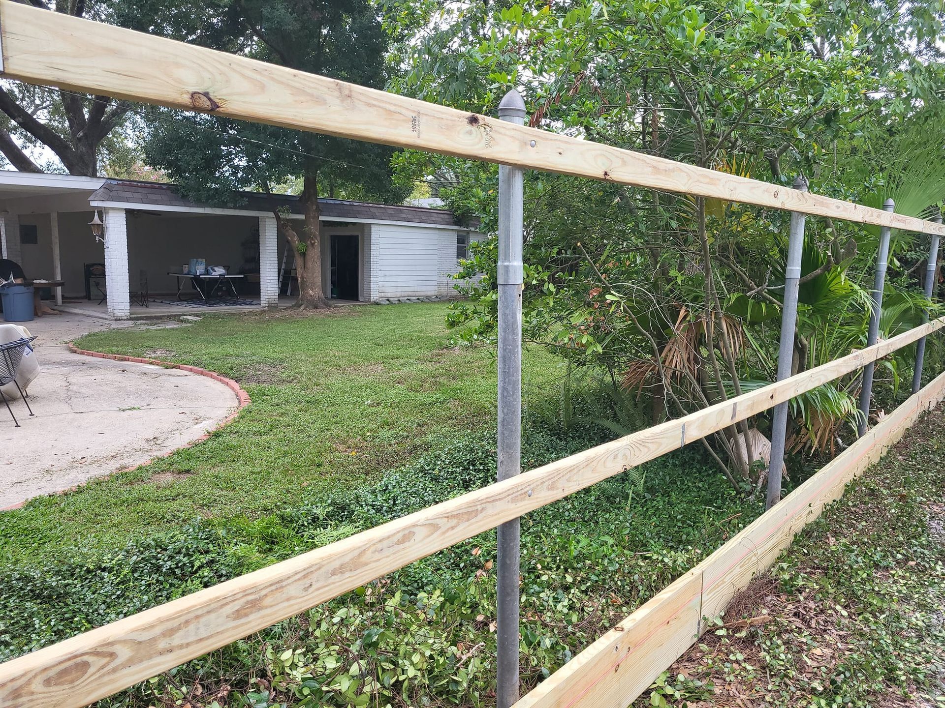 A wooden fence is being built in front of a house.