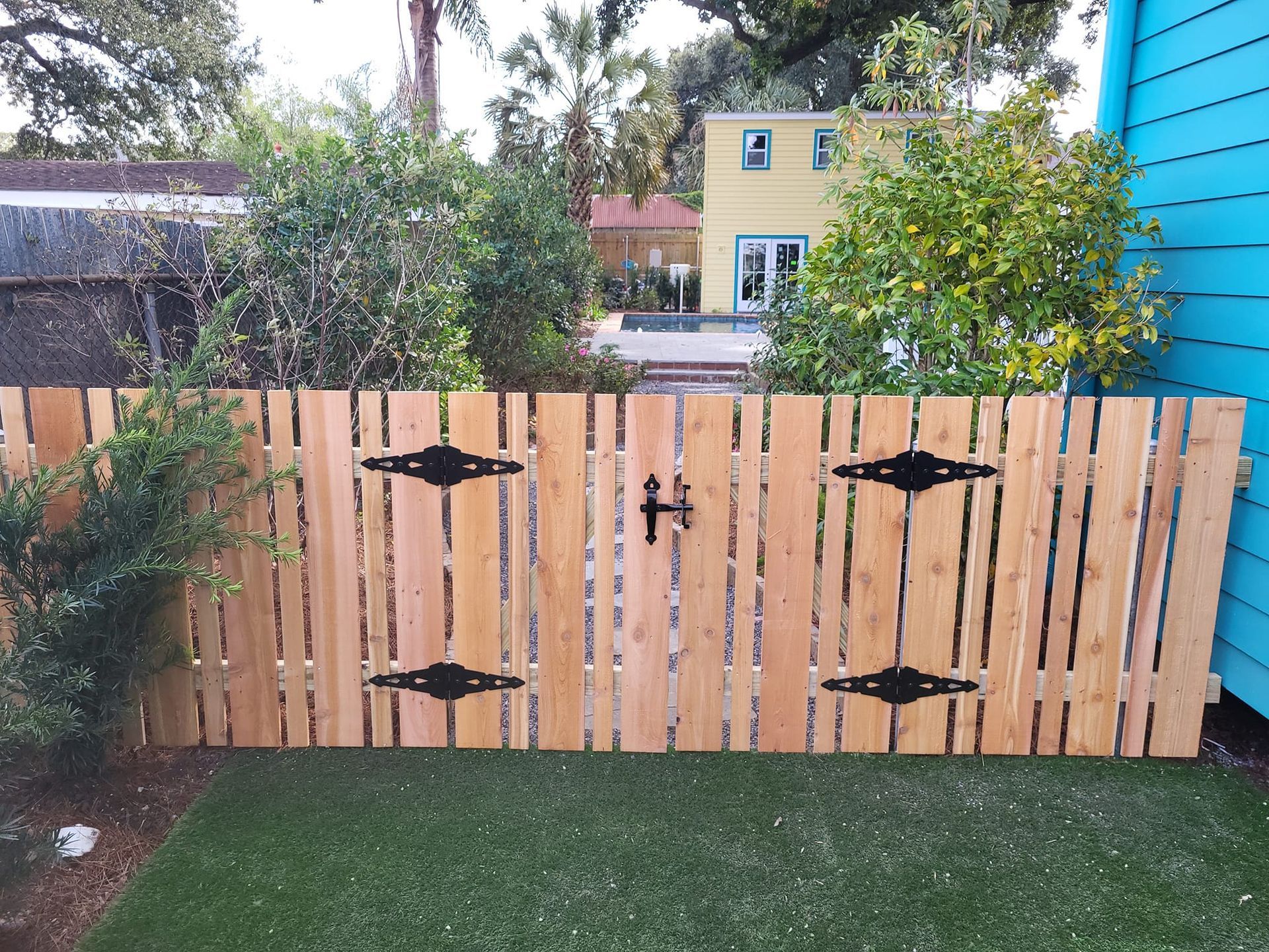 A wooden fence with a blue house in the background