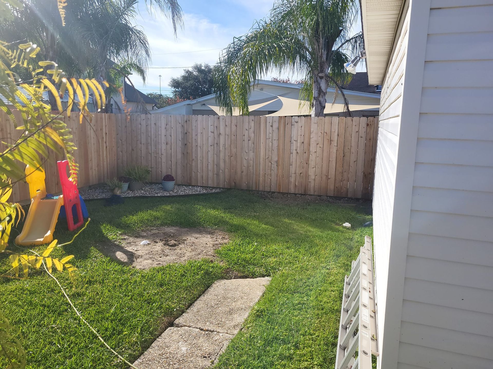 There is a wooden fence in the backyard of a house.