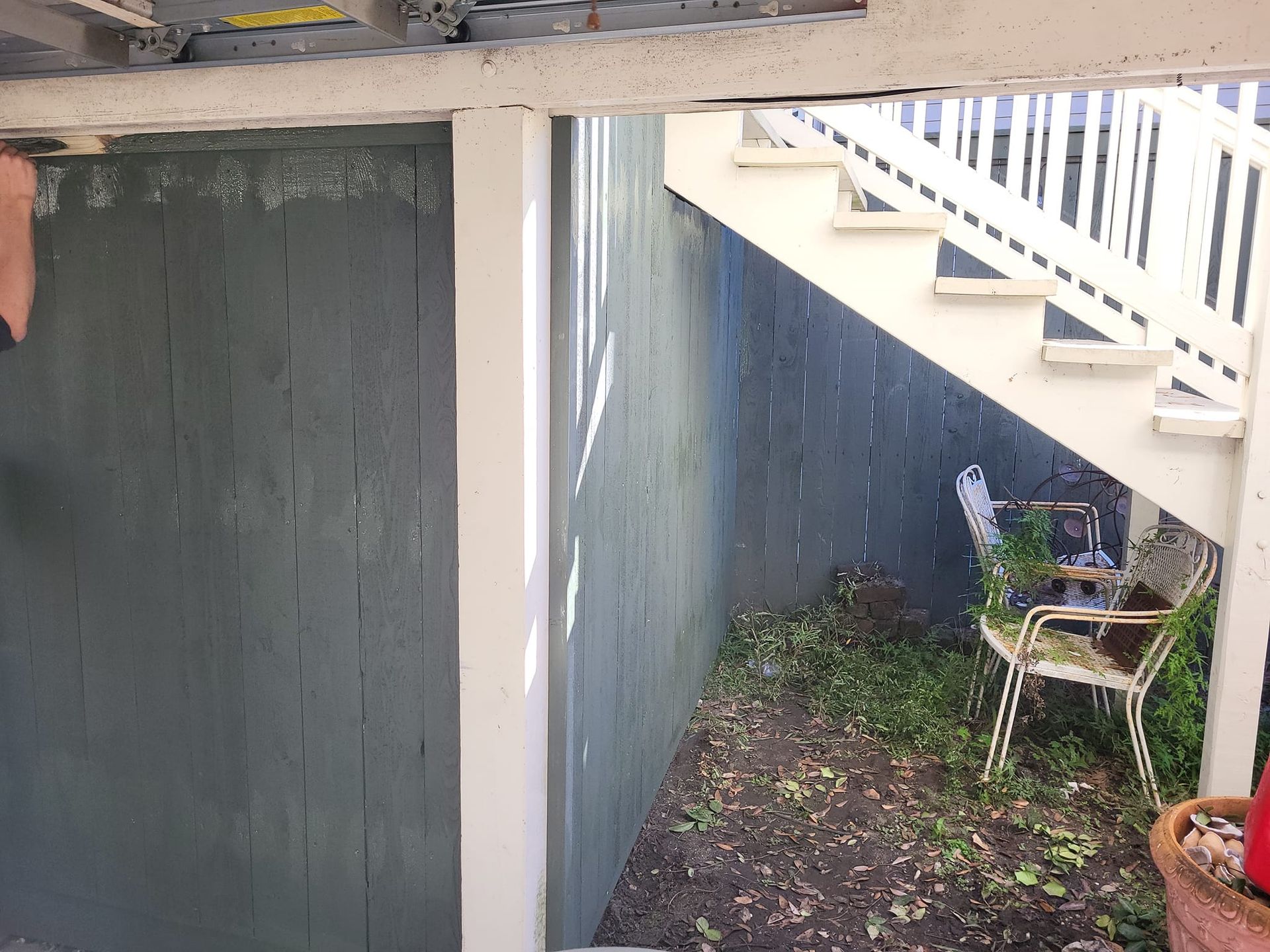 A staircase leading up to a patio with a chair and potted plants