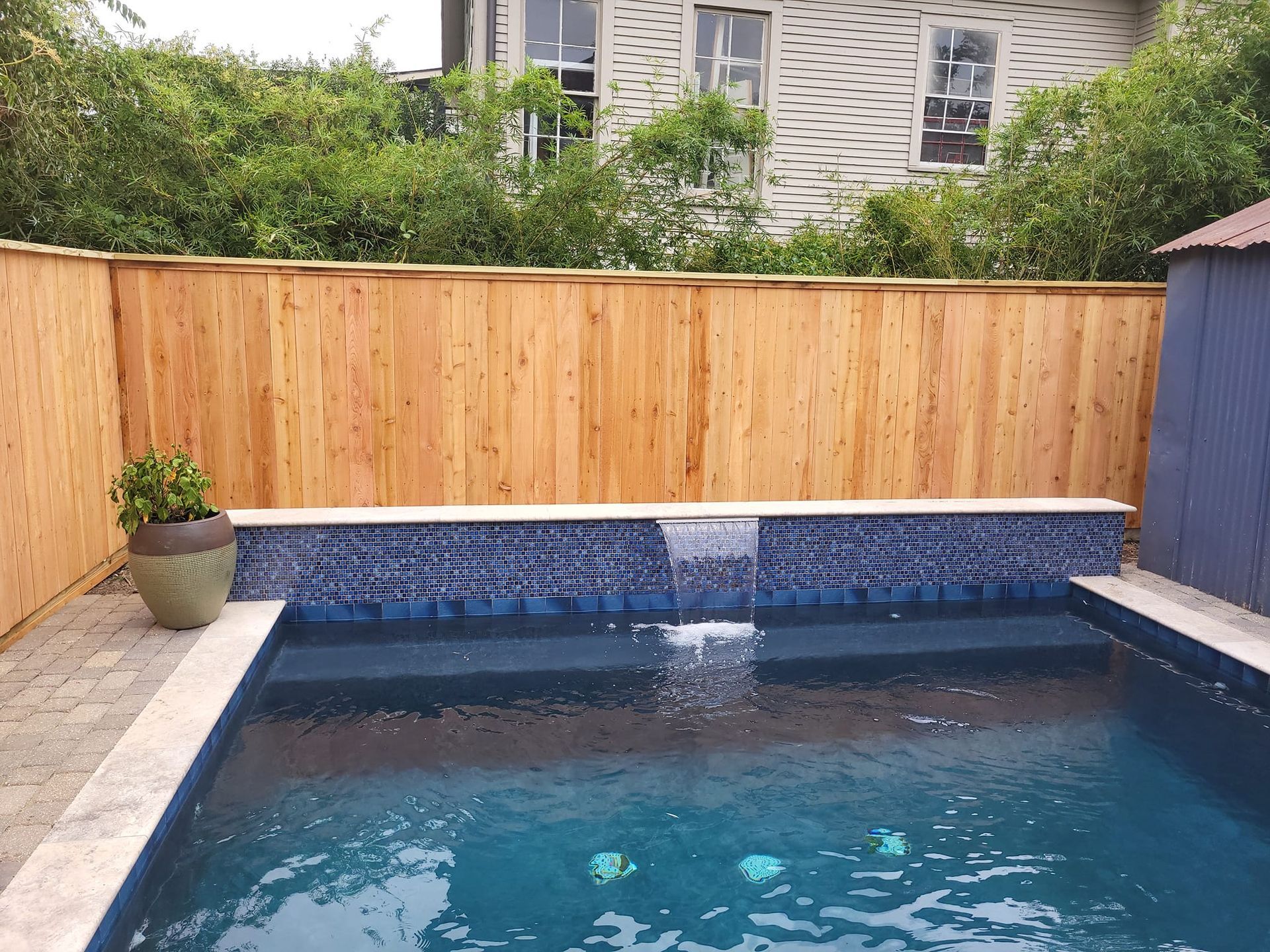 A large swimming pool with a wooden fence surrounding it