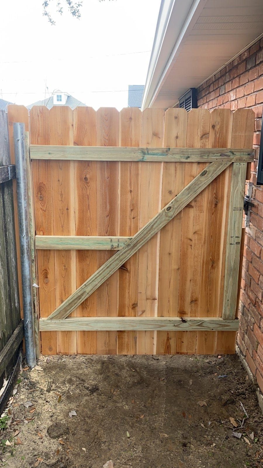 A wooden fence with a gate attached to it.