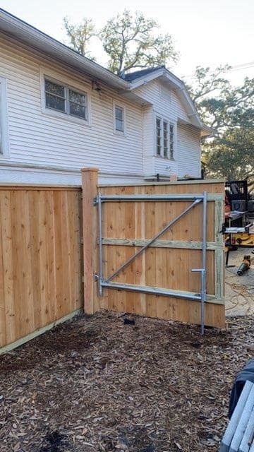 A wooden fence is being built in front of a house.
