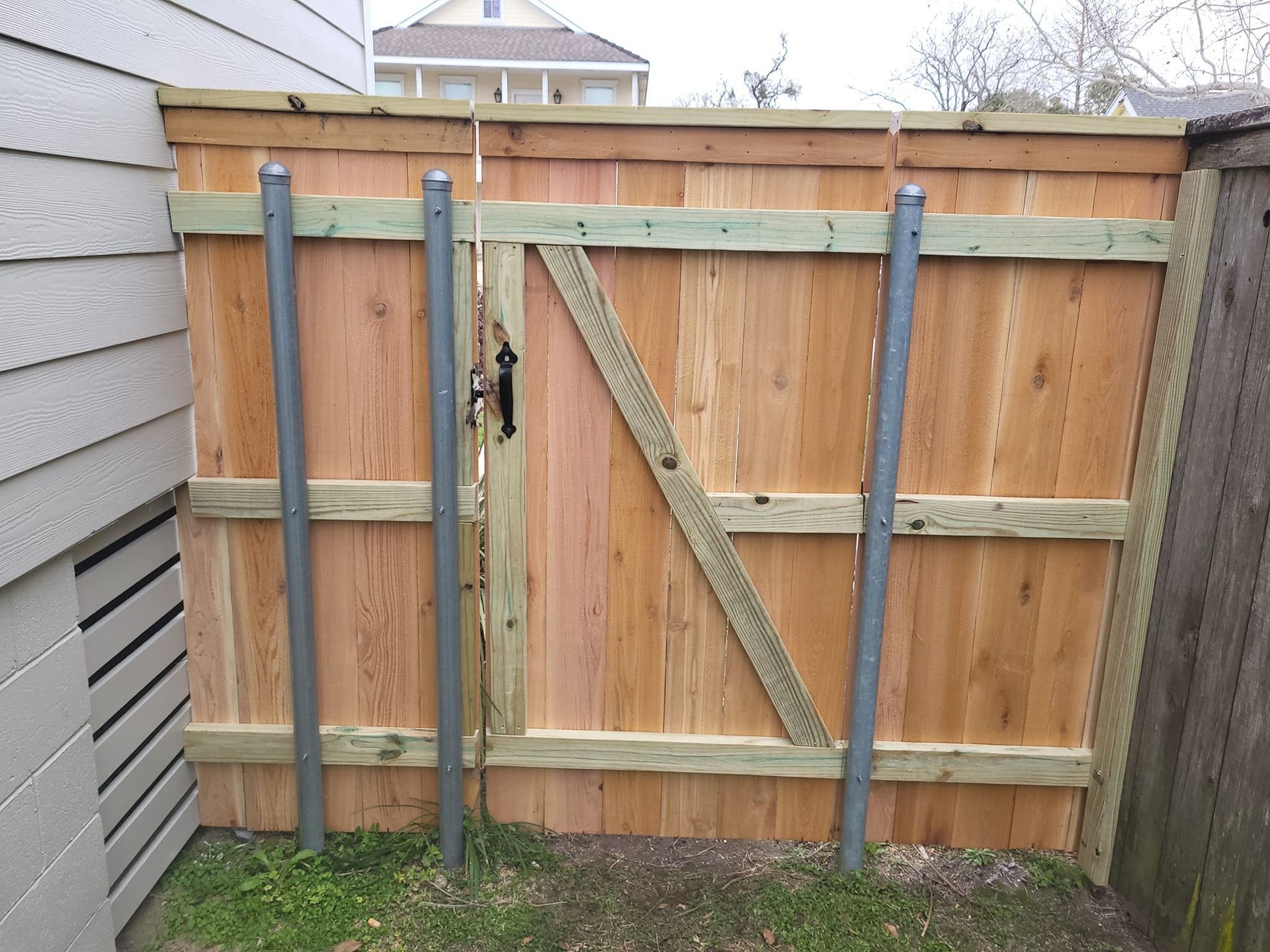 A wooden fence with a gate in the backyard