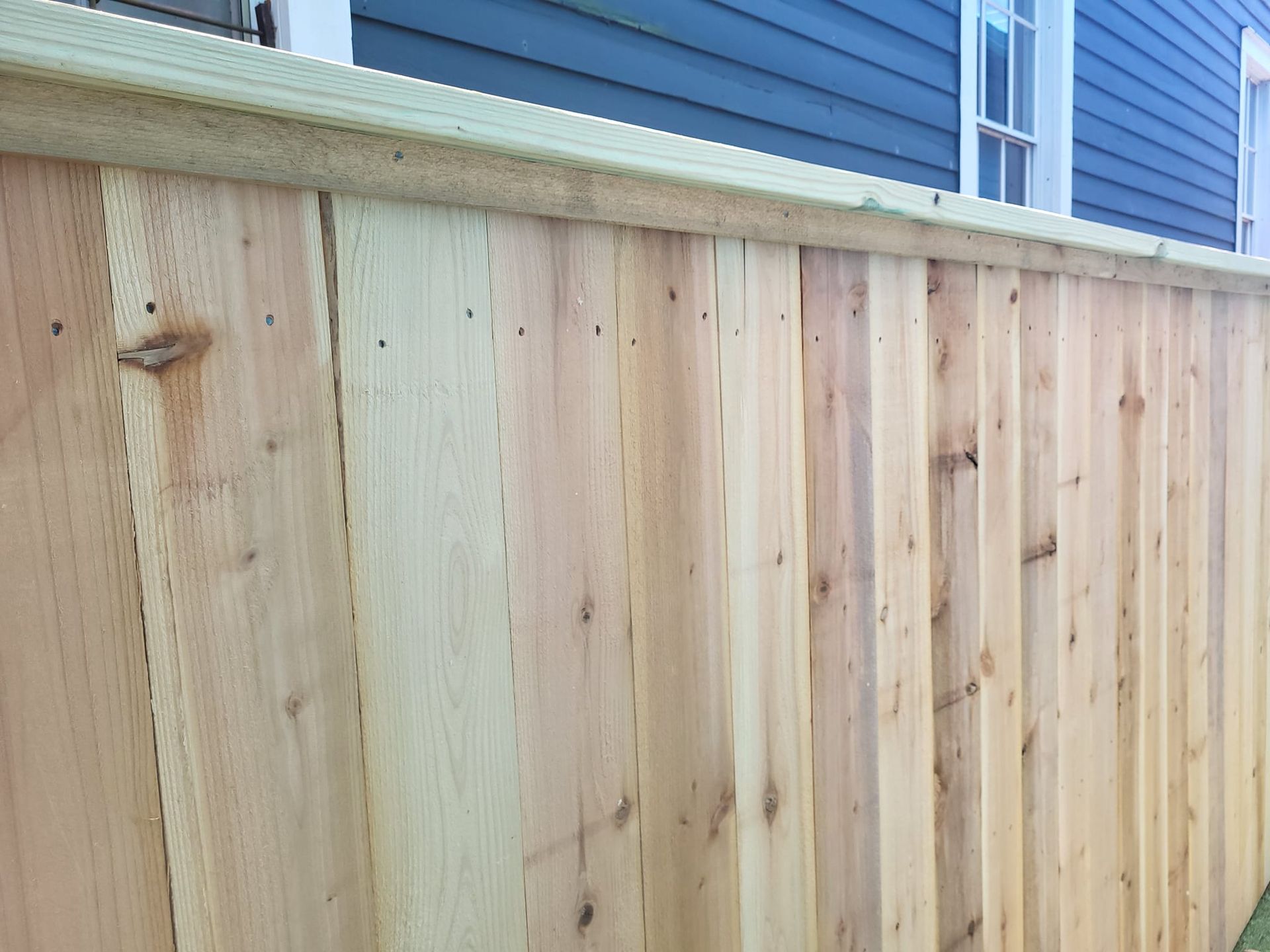 A wooden fence is sitting in front of a house.