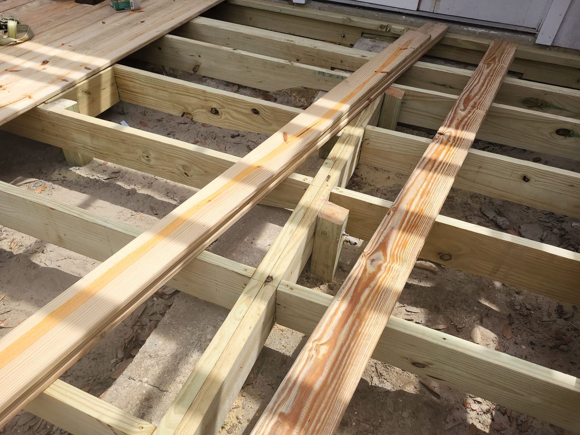 A wooden deck is being built on the ground.