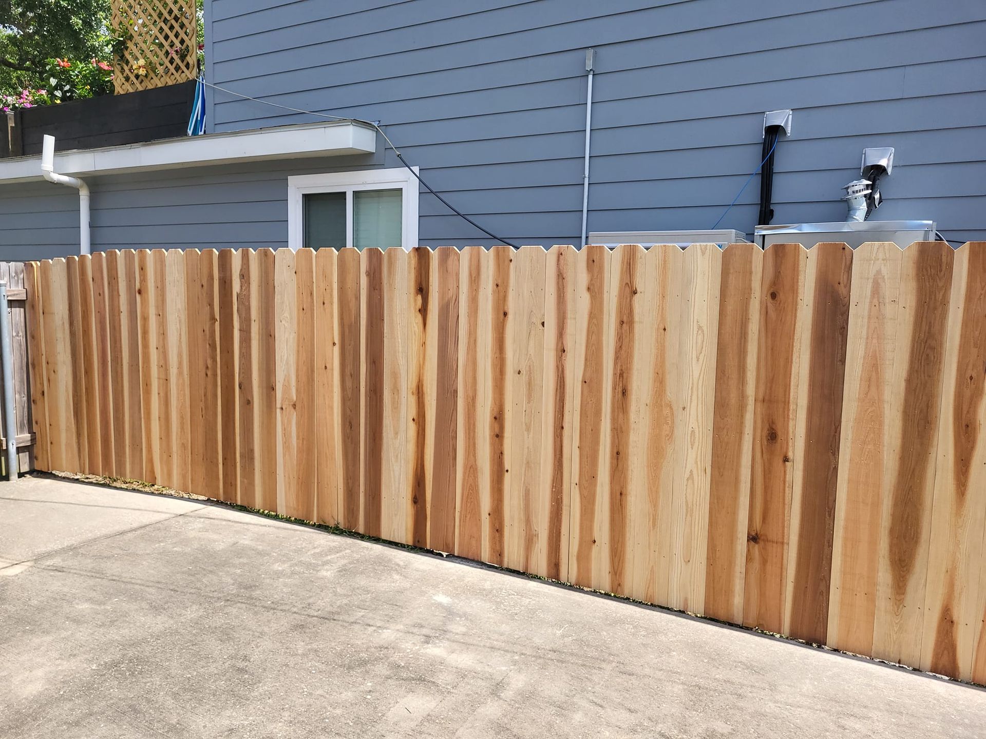 A wooden fence along the side of a house