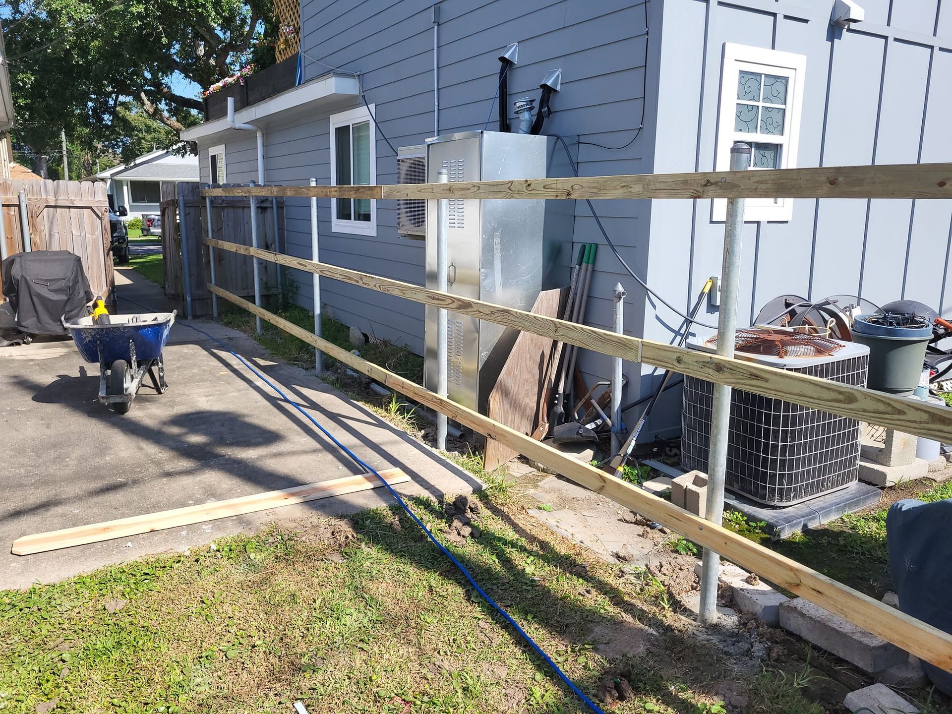 A wooden fence is being built in front of a house.