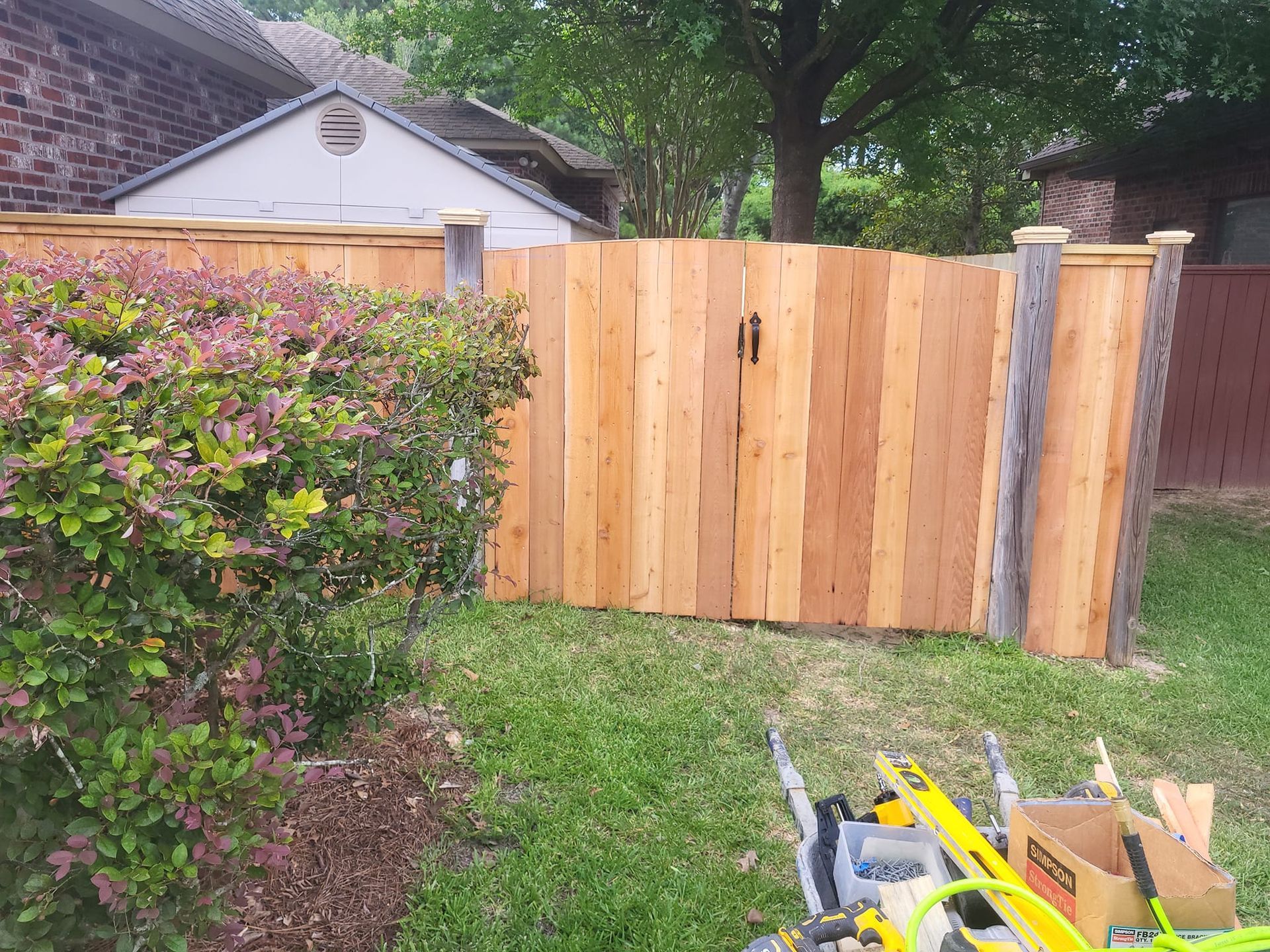 A wooden fence is being built in front of a house.