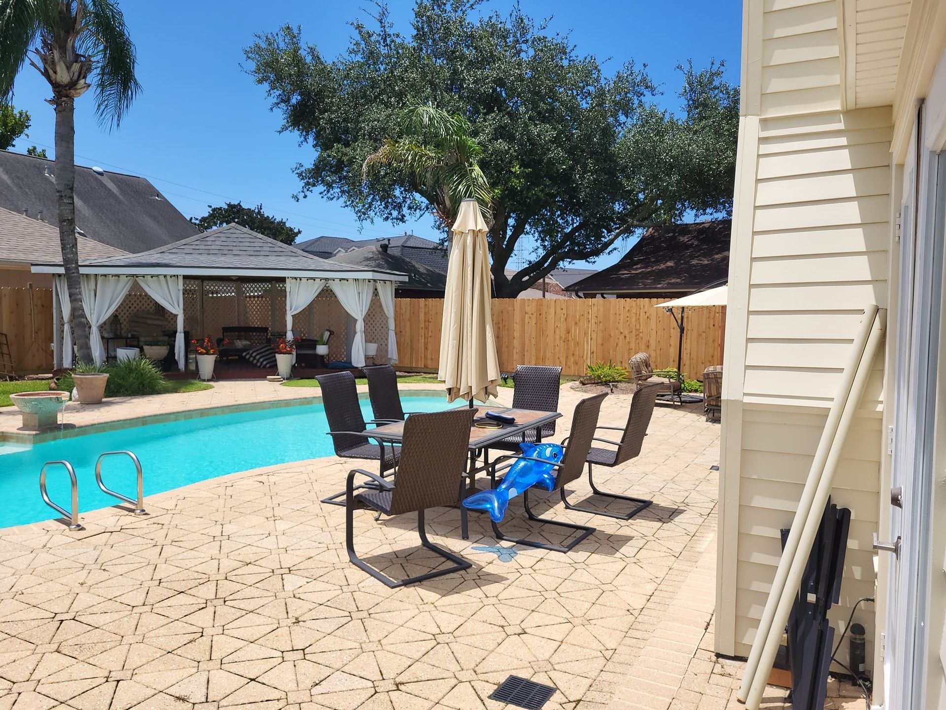 A patio with a table and chairs next to a swimming pool