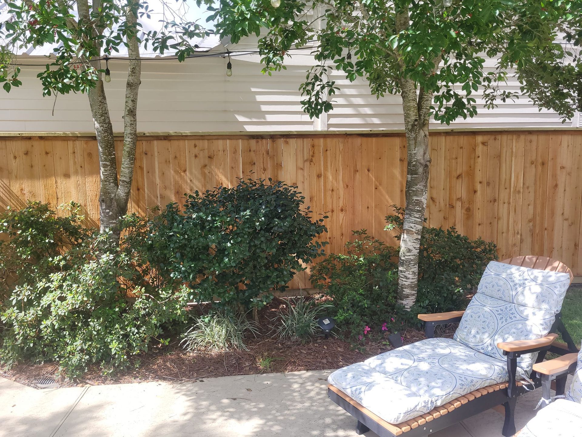 A wooden fence with a chair in front of it
