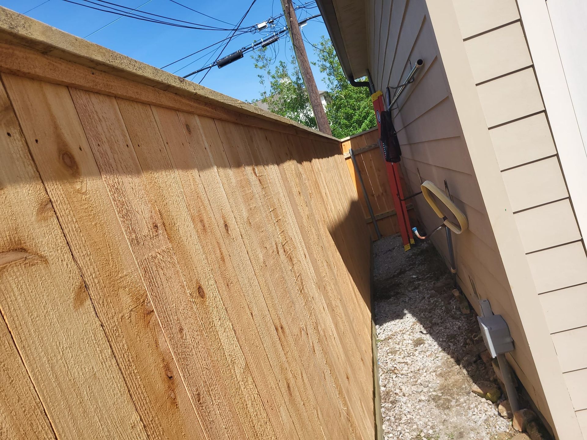 A wooden fence along the side of a house