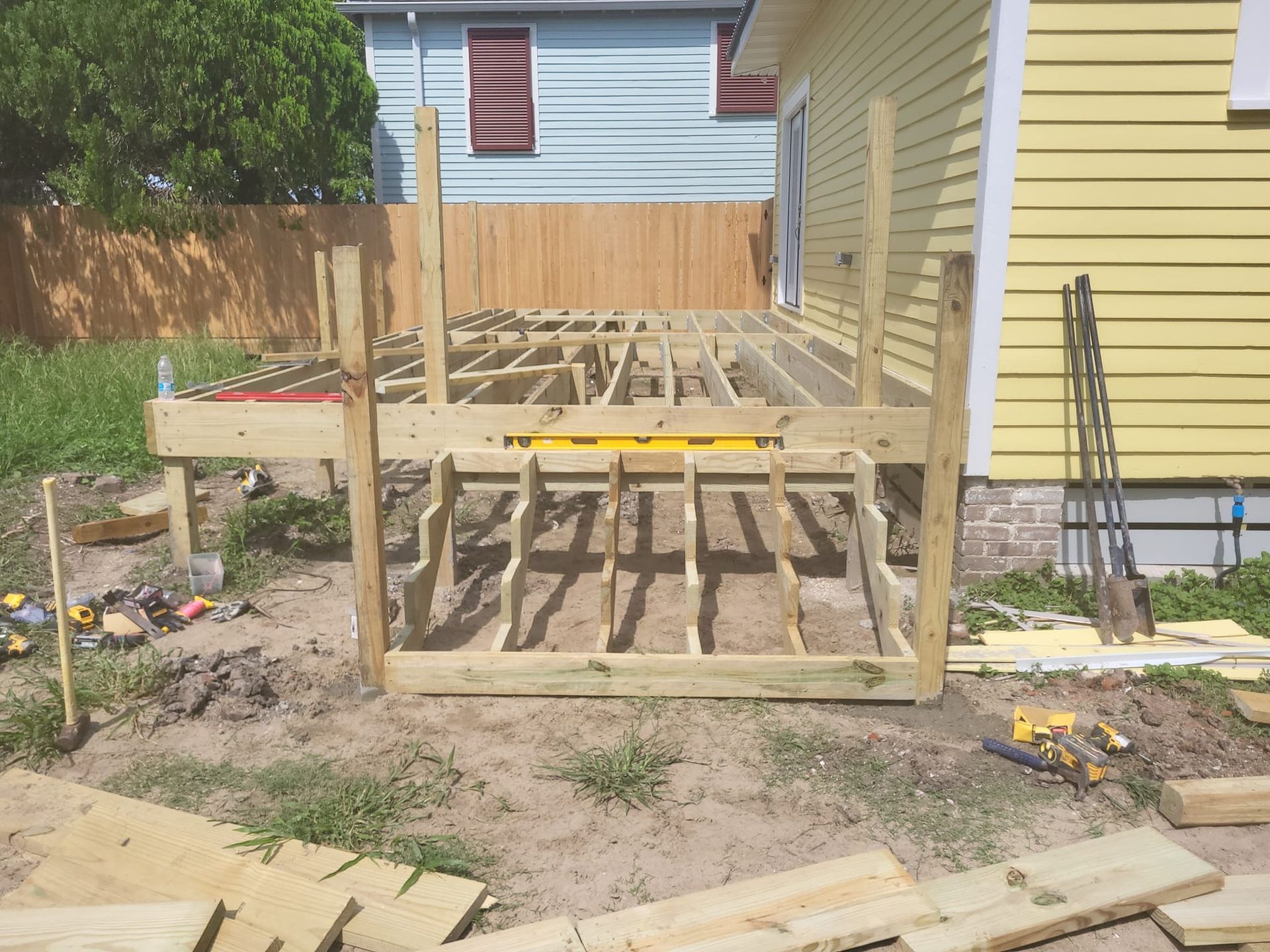 A wooden deck is being built in front of a house