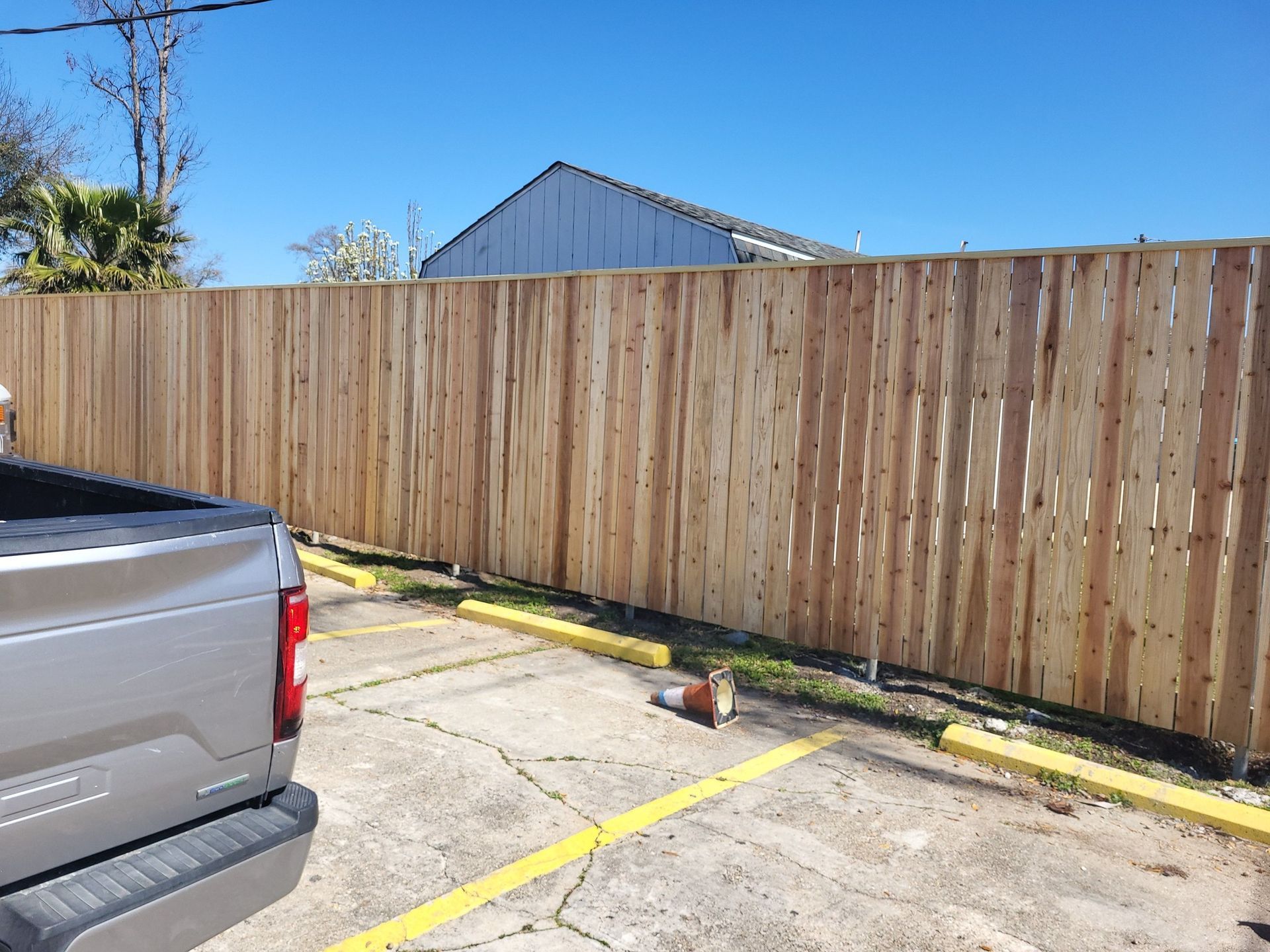 A truck is parked in front of a wooden fence.