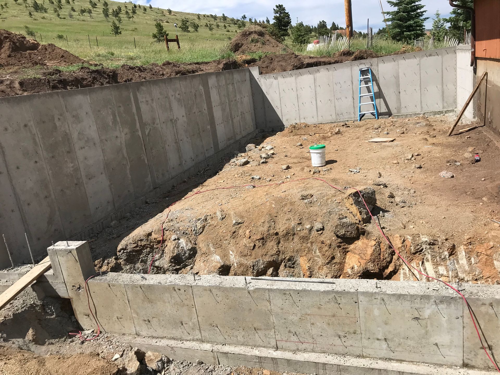 A stone wall with stairs leading up to a house.