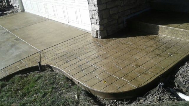 A concrete walkway with steps leading to a garage door.