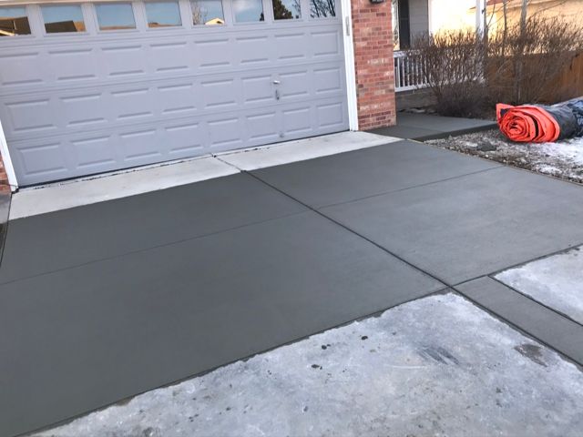 A concrete driveway with a fire hydrant in front of a garage door.