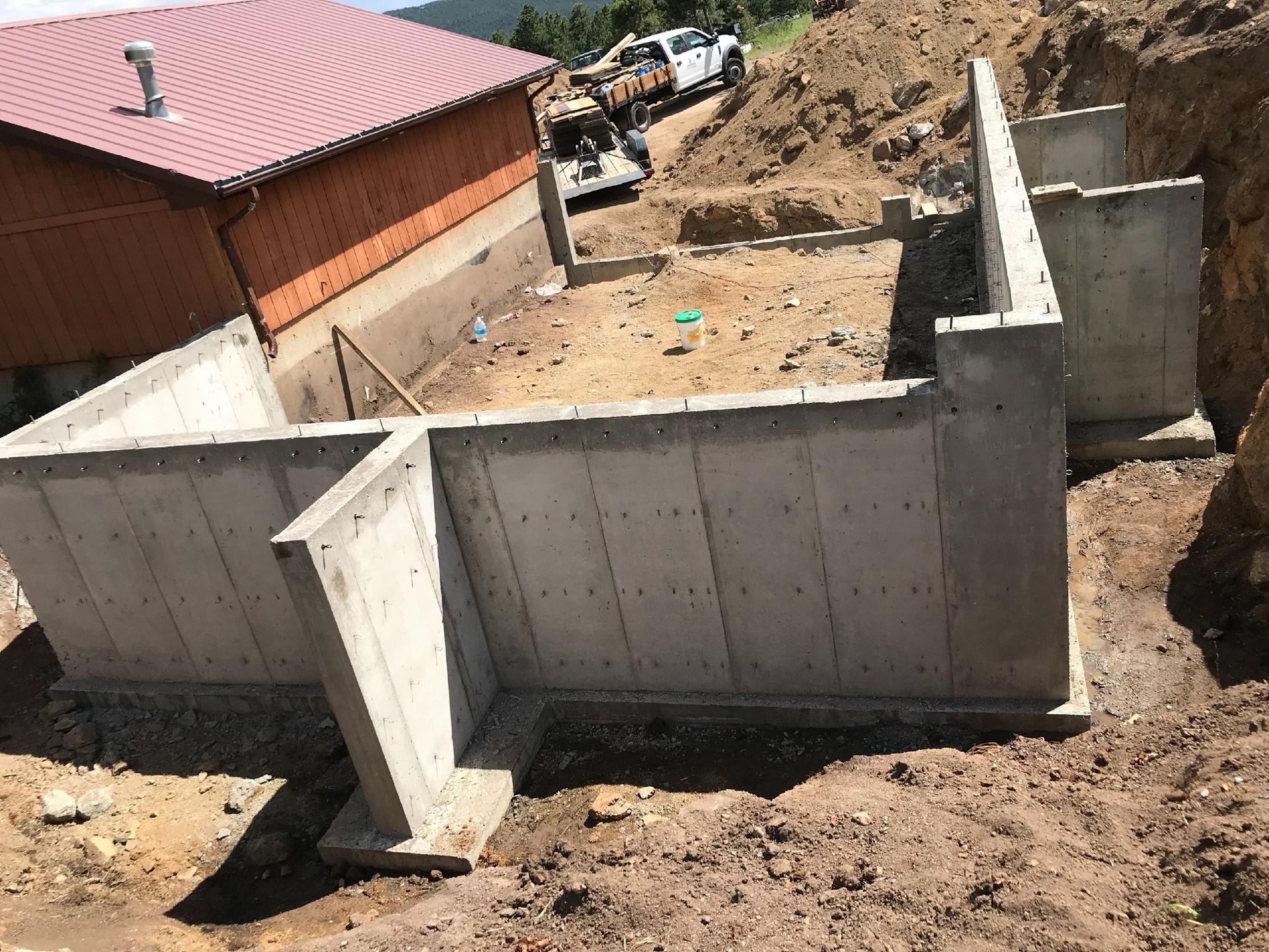 A large concrete wall is being built in front of a house.